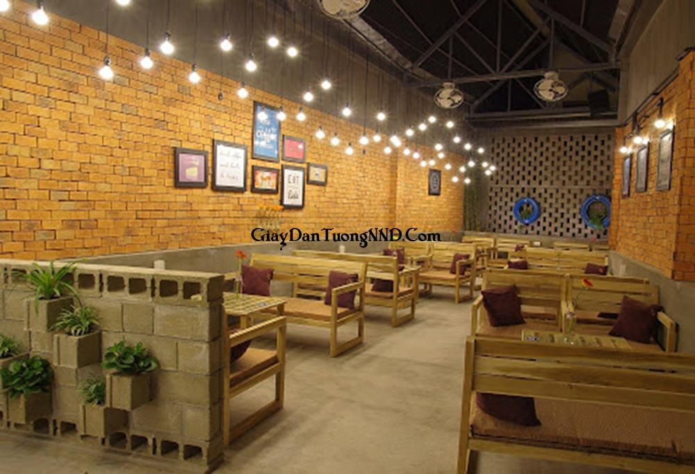 Trang trí quán cafe bằng mẫu giấy dán tường giả gạch tông màu đỏ kết hợp với đèn vàng và bàn ghế vàng tạo sự ấm cúng